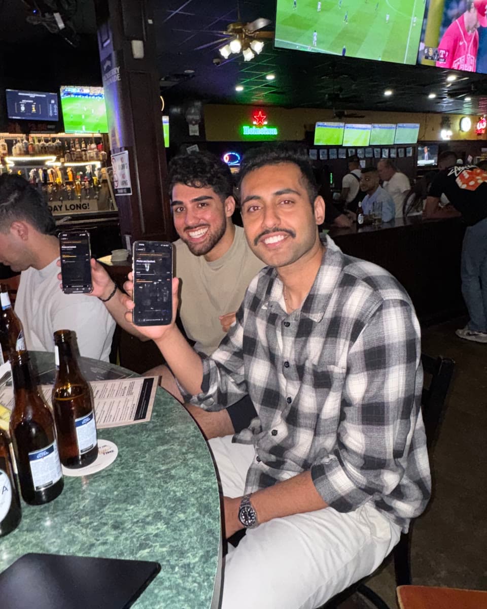 Two fans at O'Sheas holding up their phones with their Clutch picks locked